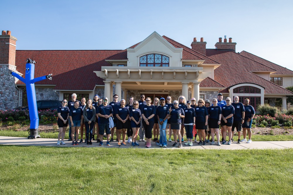 GVSU Alumni pose in front of Alumni House & Visitor Center
